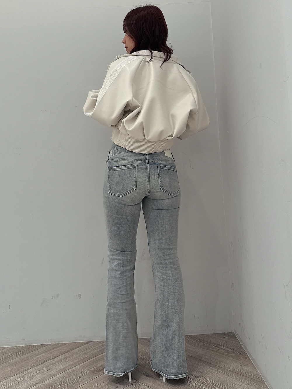 ホワイト系のブルゾン、ブラック系のニット/セーター、ブルー系のデニムパンツを着用したレディースの冬コーディネートの3枚目の写真