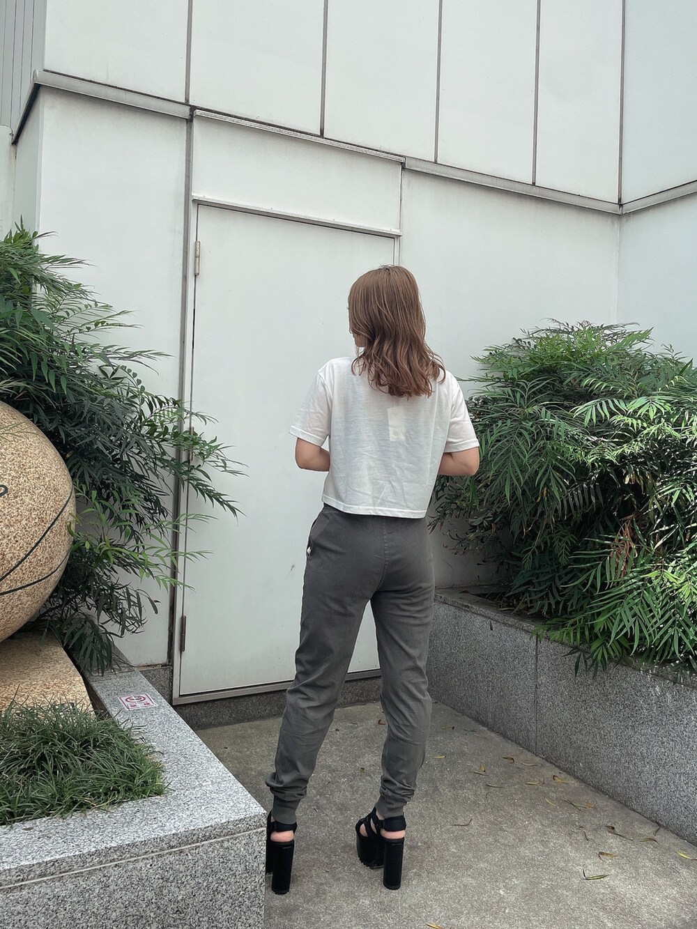 ブラック系のキャミソール、グレー系のスウェットパンツ、ブラック系のサンダルを着用したレディースの春コーディネートの2枚目の写真