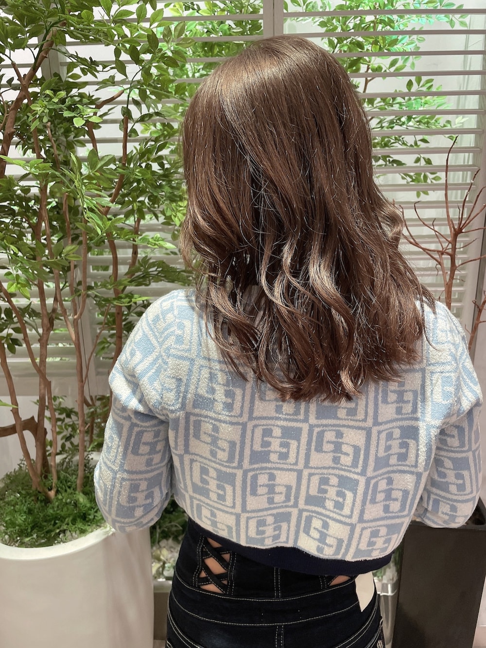 ブルー系のカーディガン/ボレロ、ブルー系のニット/セーター、ブルー系のデニムパンツを着用したレディースの春コーディネートの3枚目の写真