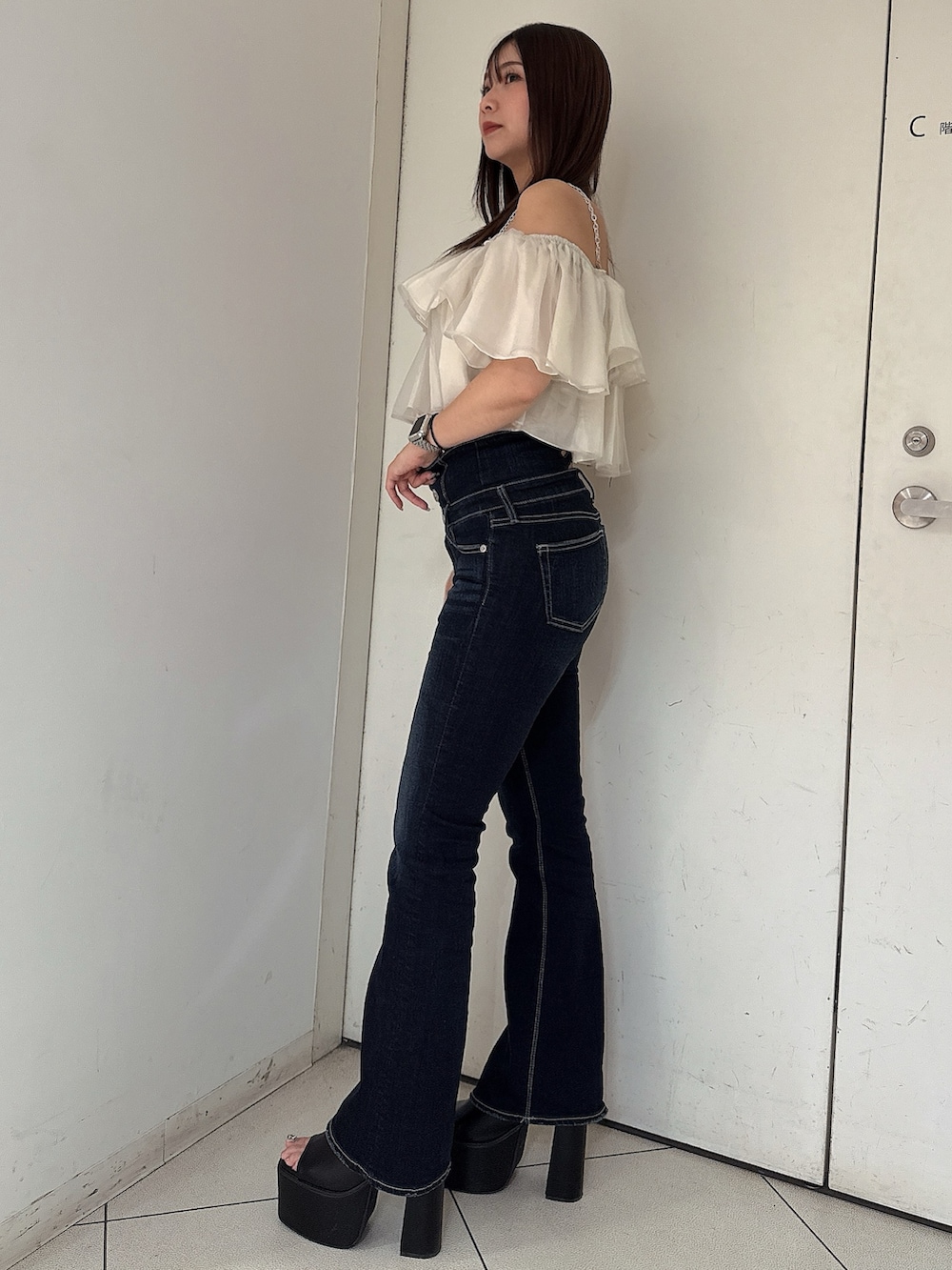 ブルー系のデニムパンツ、ブラック系のサンダル、ベージュ系のシャツ/ブラウスを着用したレディースの夏コーディネートの2枚目の写真