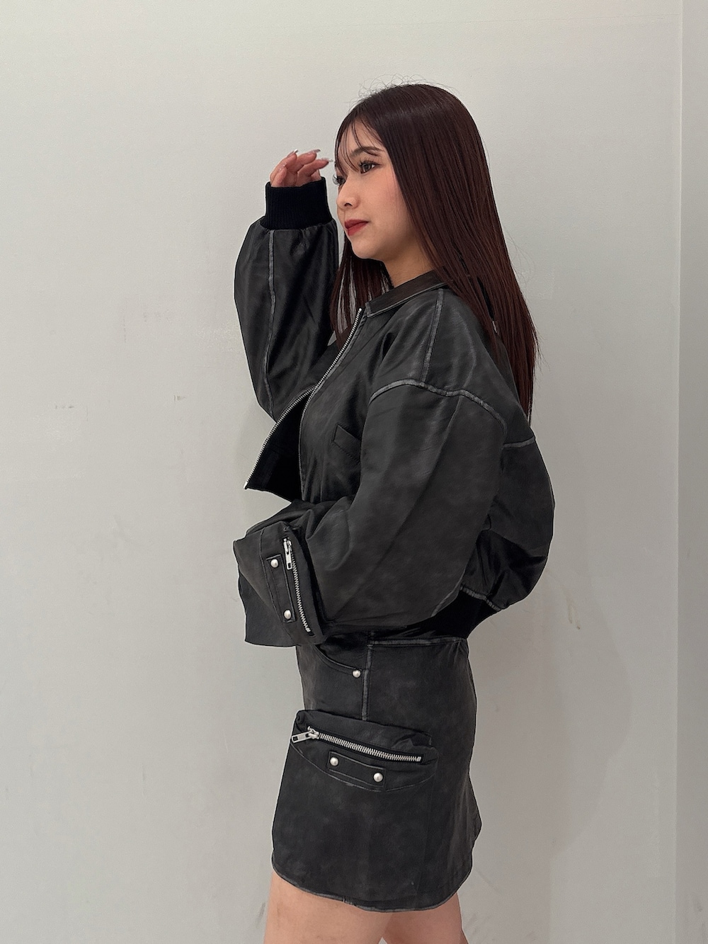 ブラック系のブーツ、ホワイト系のニット/セーター、ブラック系のスカートを着用したレディースの秋コーディネートの5枚目の写真