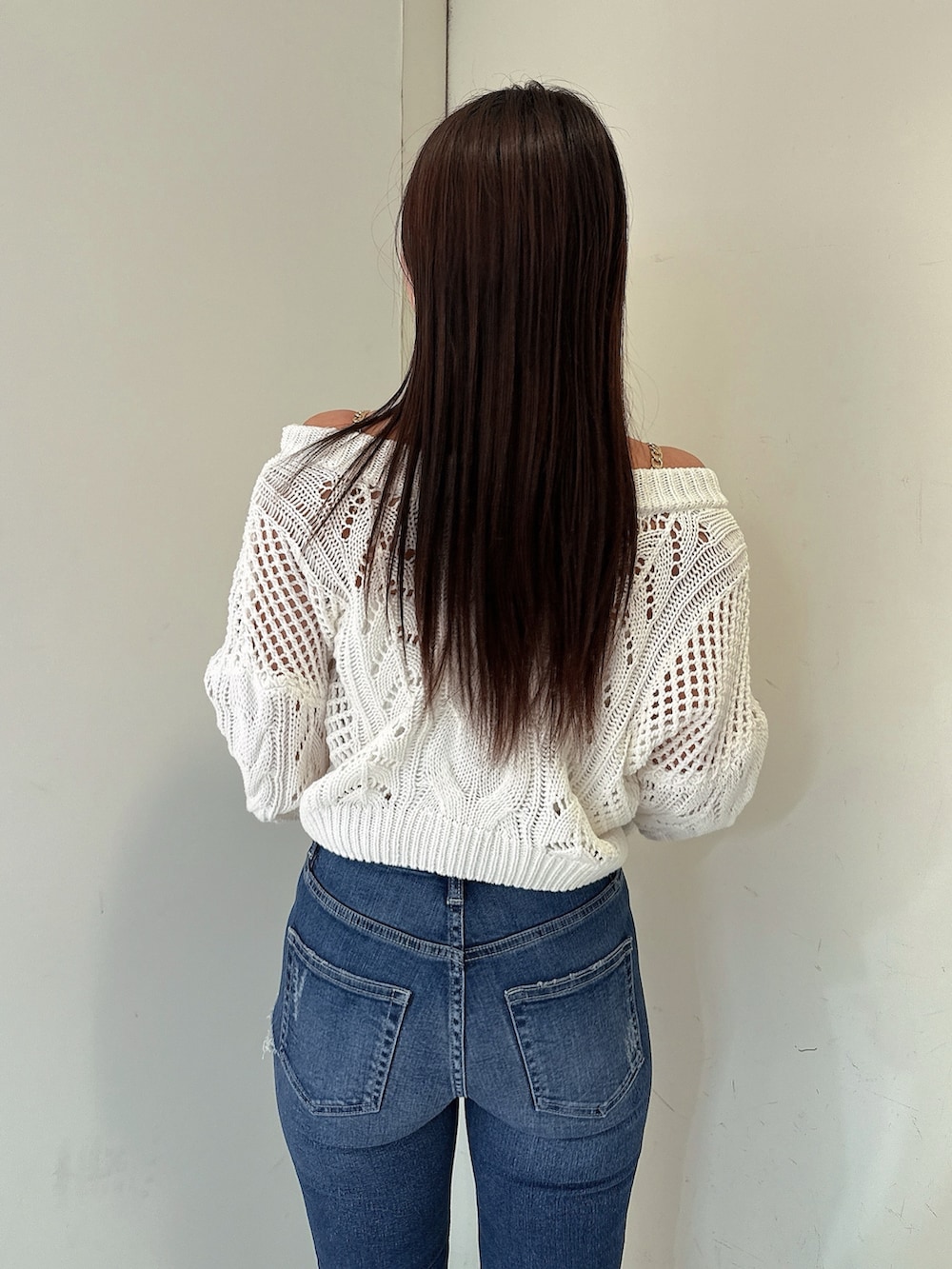 ホワイト系のニット/セーター、ブルー系のデニムパンツ、ピンク系のパンプスを着用したレディースの春コーディネートの6枚目の写真