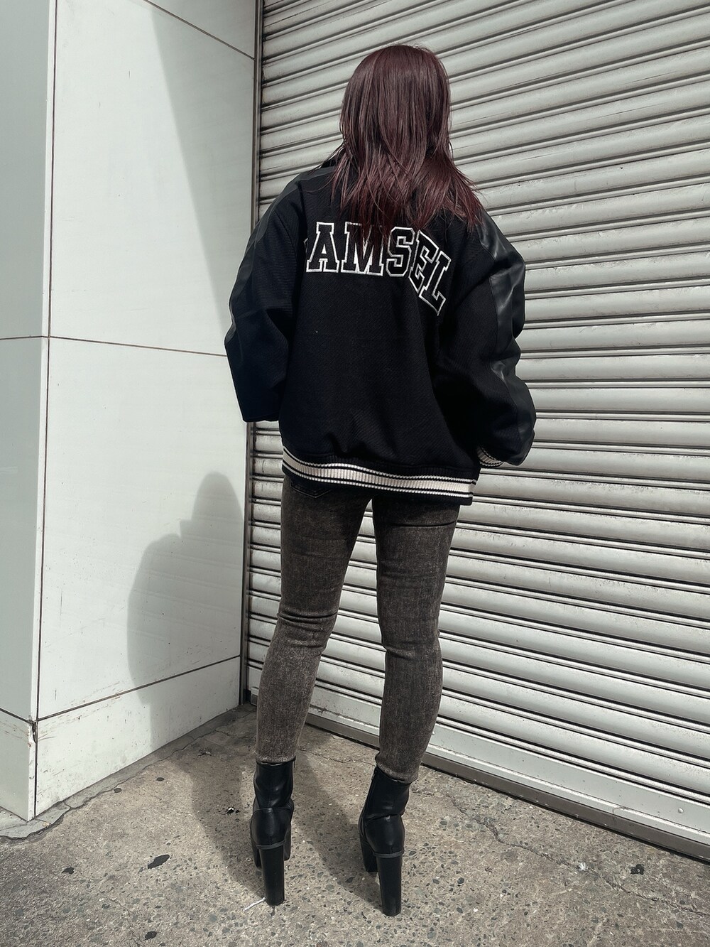 ブラック系のスタジャン、ブラック系のニット/セーター、ブラック系のデニムパンツを着用したレディースの秋コーディネートの3枚目の写真