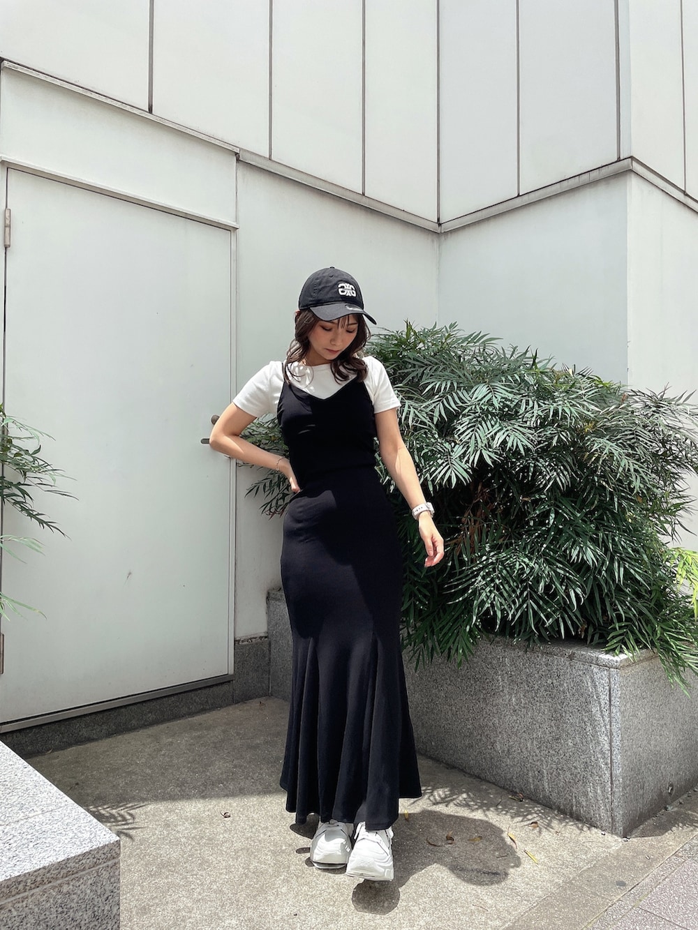 ブラック系のワンピース、ホワイト系のスニーカー、ホワイト系のTシャツ/カットソーを着用したレディースの夏コーディネートの2枚目の写真