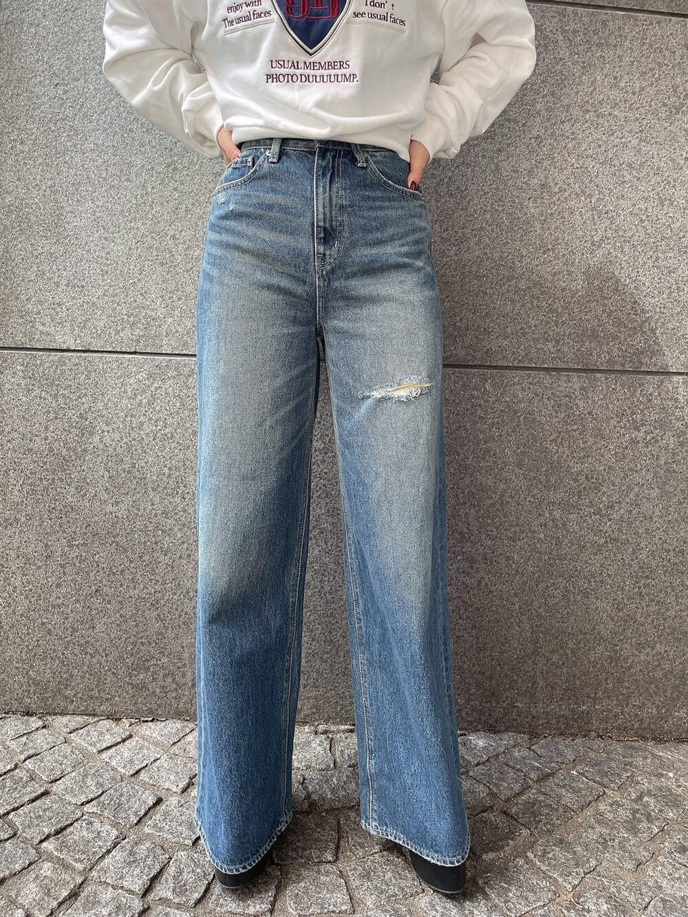 ブラック系のブーツ、ブラック系のデニムパンツ、ホワイト系のスウェットを着用したレディースの秋コーディネートの7枚目の写真