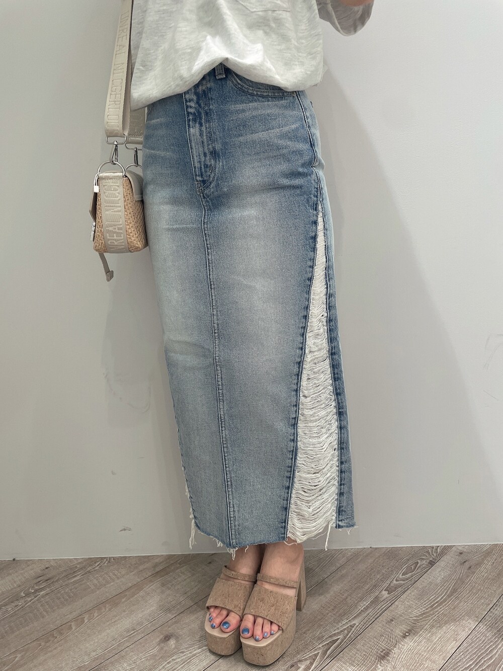 ホワイト系のTシャツ/カットソー、ブルー系のデニムスカート、ホワイト系のサンダルを着用したレディースの春コーディネートの8枚目の写真