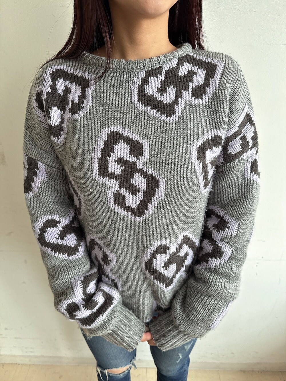 グレー系のニット/セーター、ブルー系のデニムパンツ、ブラック系のブーツを着用したレディースの秋コーディネートの7枚目の写真