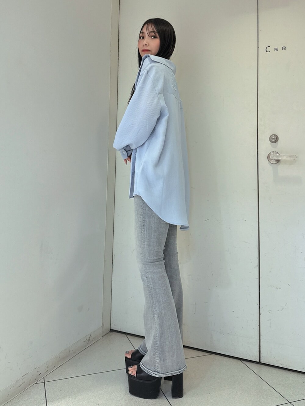 ブルー系のデニムパンツ、ブラック系のサンダル、ホワイト系のキャミソールを着用したレディースの春コーディネートの2枚目の写真