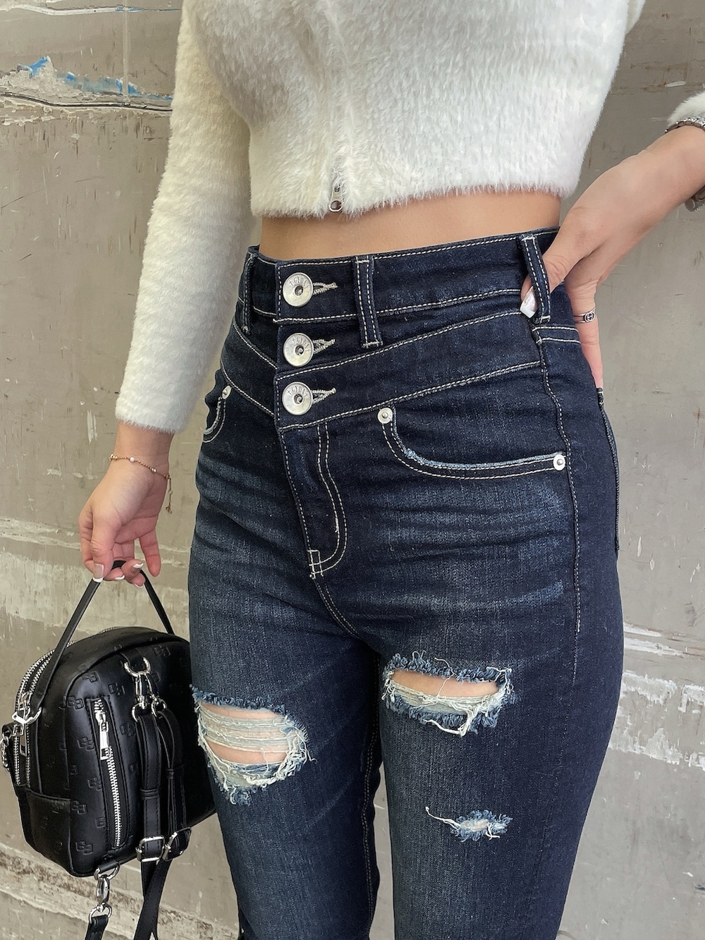 ホワイト系のブルゾン、ホワイト系のニット/セーター、ブルー系のデニムパンツを着用したレディースの冬コーディネートの9枚目の写真