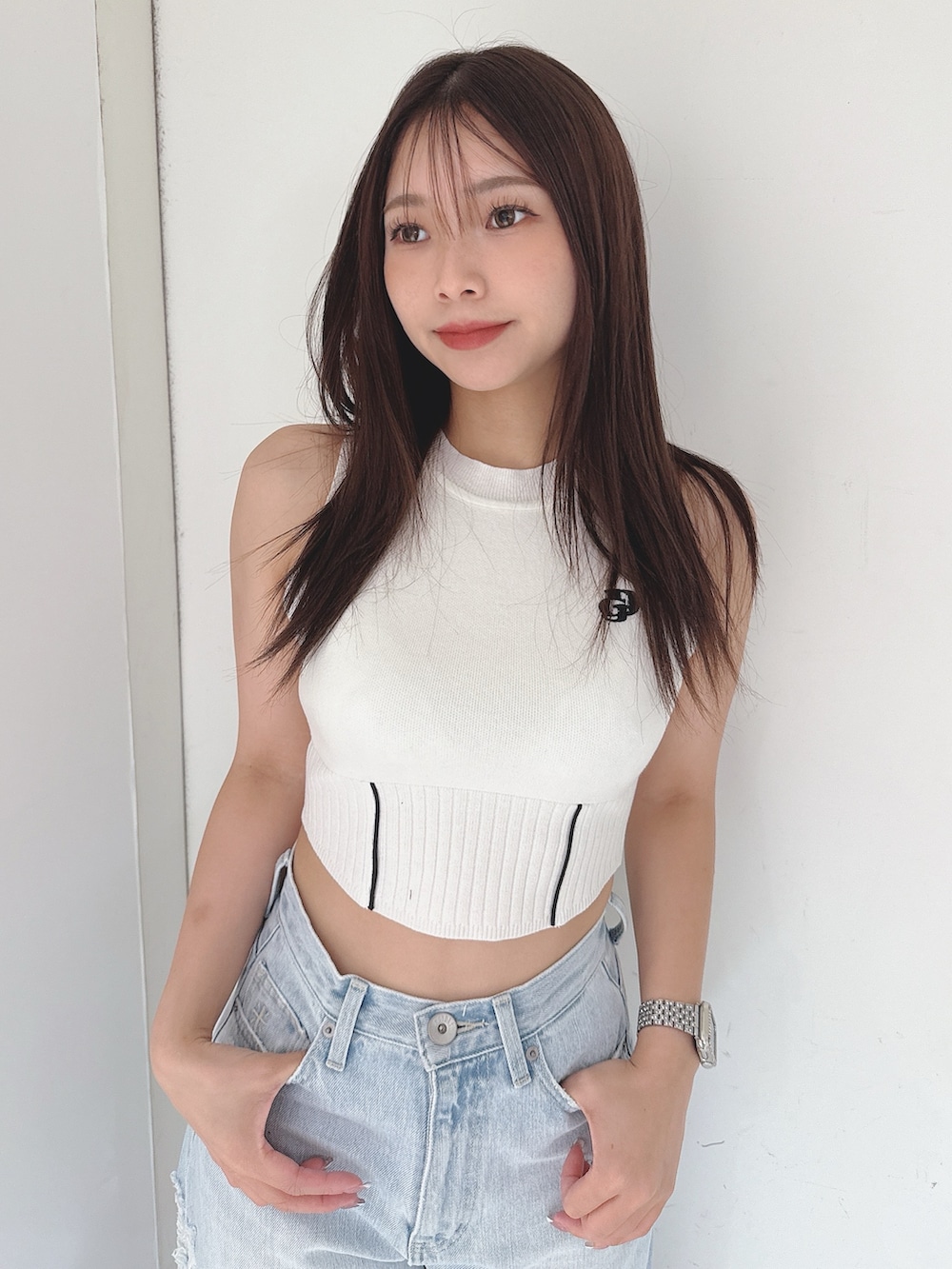 ホワイト系のニット/セーター、ブルー系のデニムパンツ、ホワイト系のサンダルを着用したレディースの夏コーディネートの4枚目の写真