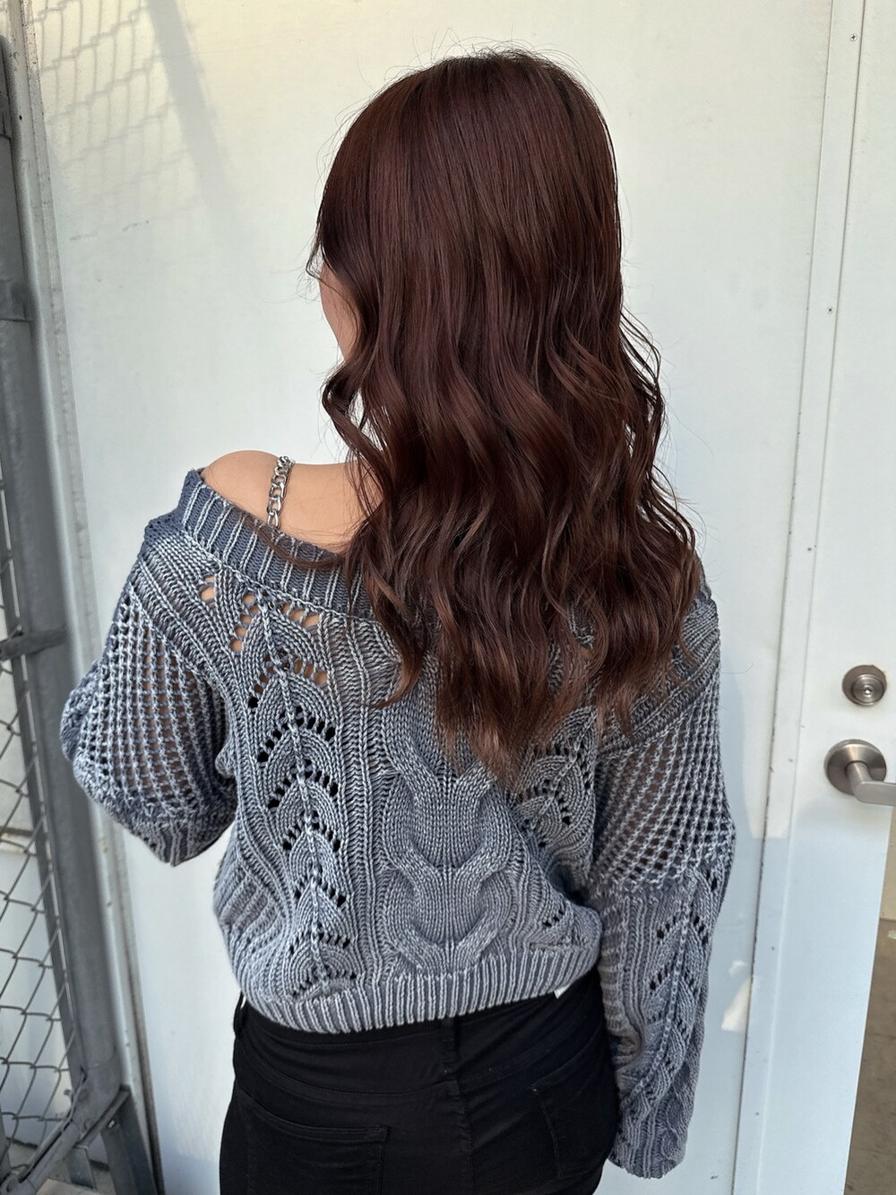 ブルー系のニット/セーター、ブラック系のデニムパンツ、ホワイト系のパンプスを着用したレディースの春コーディネートの6枚目の写真