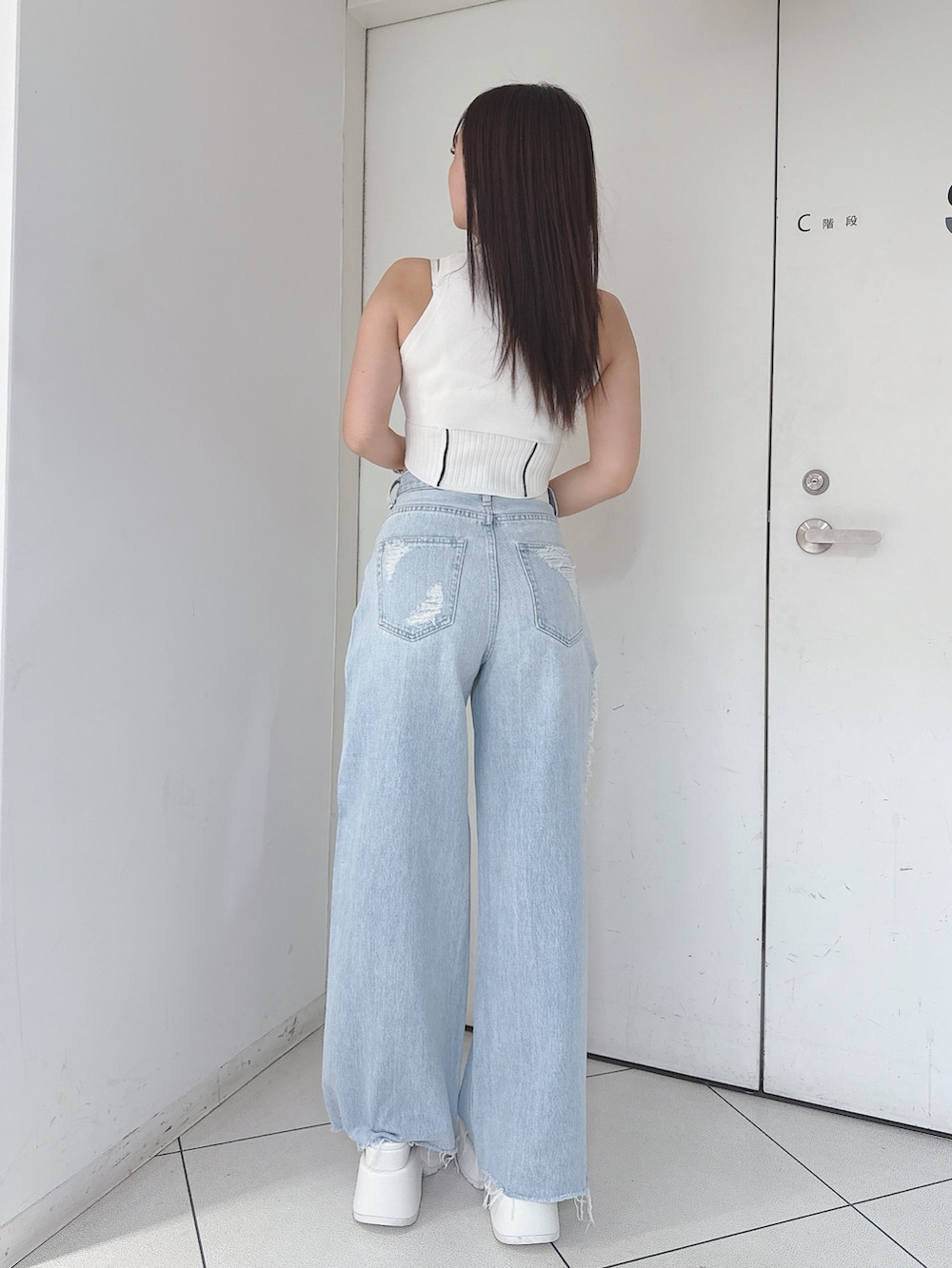 ホワイト系のニット/セーター、ブルー系のデニムパンツ、ホワイト系のサンダルを着用したレディースの夏コーディネートの3枚目の写真