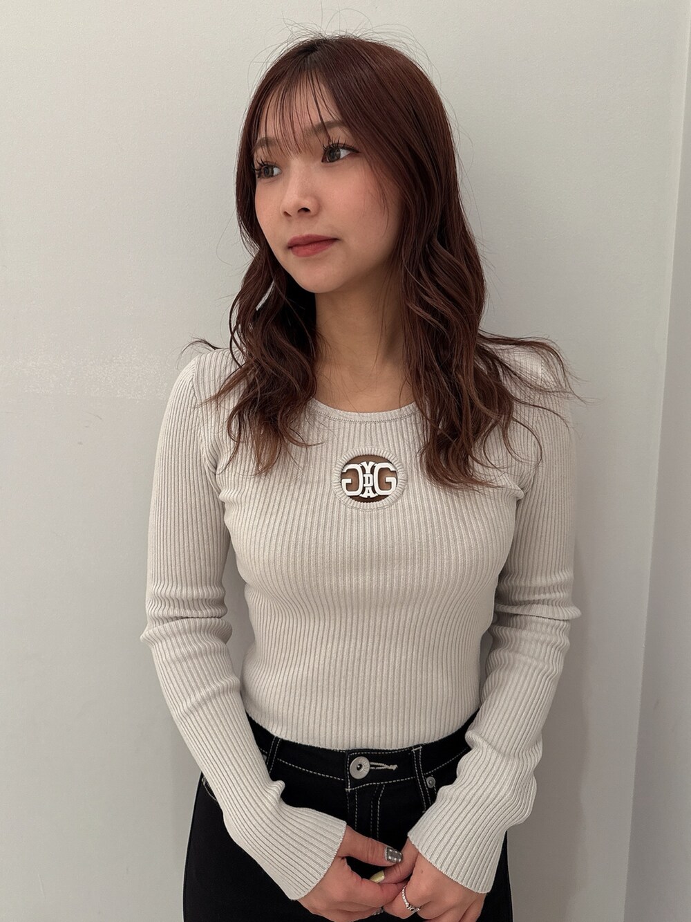 ブラック系のテーラードジャケット、グレー系のニット/セーター、ブラック系のデニムパンツを着用したレディースの冬コーディネートの8枚目の写真