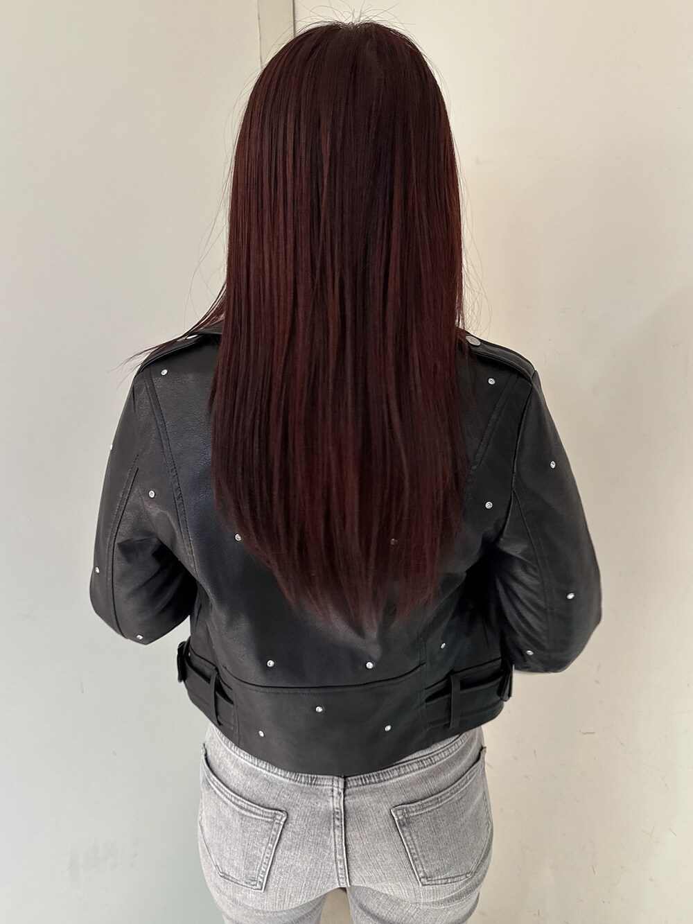 グレー系のデニムパンツ、ブラック系のブーツ、ブラック系のライダースジャケットを着用したレディースの夏コーディネートの6枚目の写真