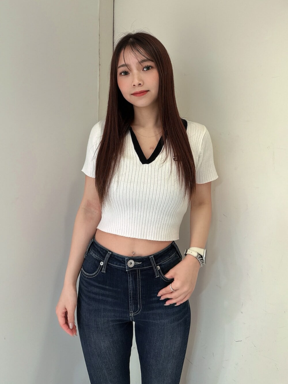 ブルー系のデニムパンツ、ブラック系のサンダル、ホワイト系のニット/セーターを着用したレディースの春コーディネートの4枚目の写真