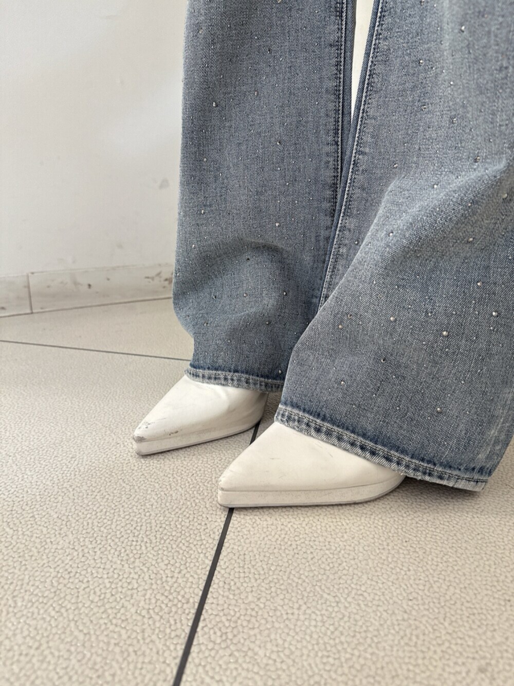 ホワイト系のサンダル、ホワイト系のTシャツ/カットソー、ブルー系のデニムパンツを着用したレディースの春コーディネートの9枚目の写真