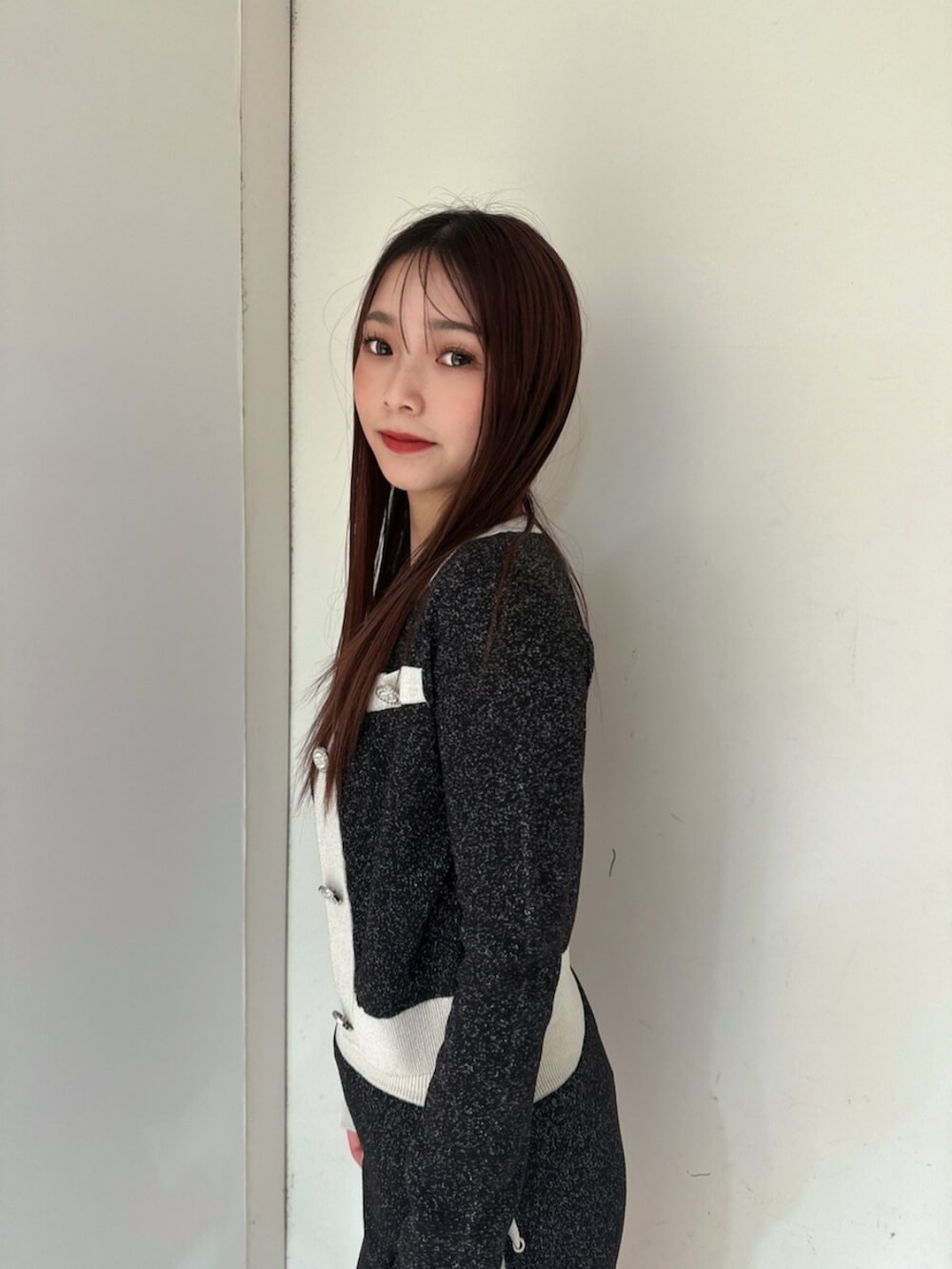 ブラック系のニット/セーター、ブラック系のスカート、ブラック系のブーツを着用したレディースの春コーディネートの5枚目の写真