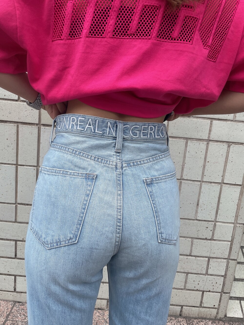 ブルー系のデニムパンツ、ホワイト系のサンダル、ピンク系のTシャツ/カットソーを着用したレディースの夏コーディネートの5枚目の写真