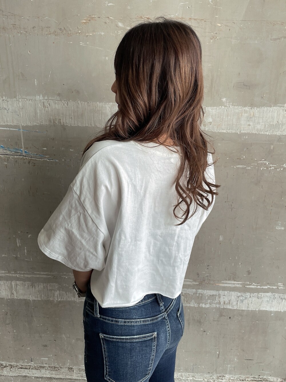 ホワイト系のTシャツ/カットソー、ブラック系のキャミソール、ブルー系のデニムパンツを着用したレディースの夏コーディネートの5枚目の写真
