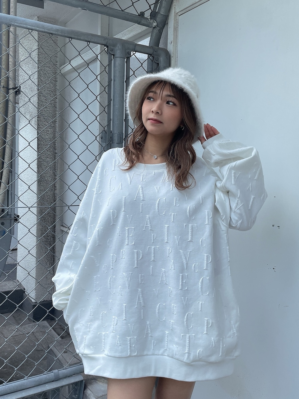 ホワイト系のスウェット、ブラック系のスカート、ベージュ系のブーツを着用したレディースの冬コーディネートの4枚目の写真