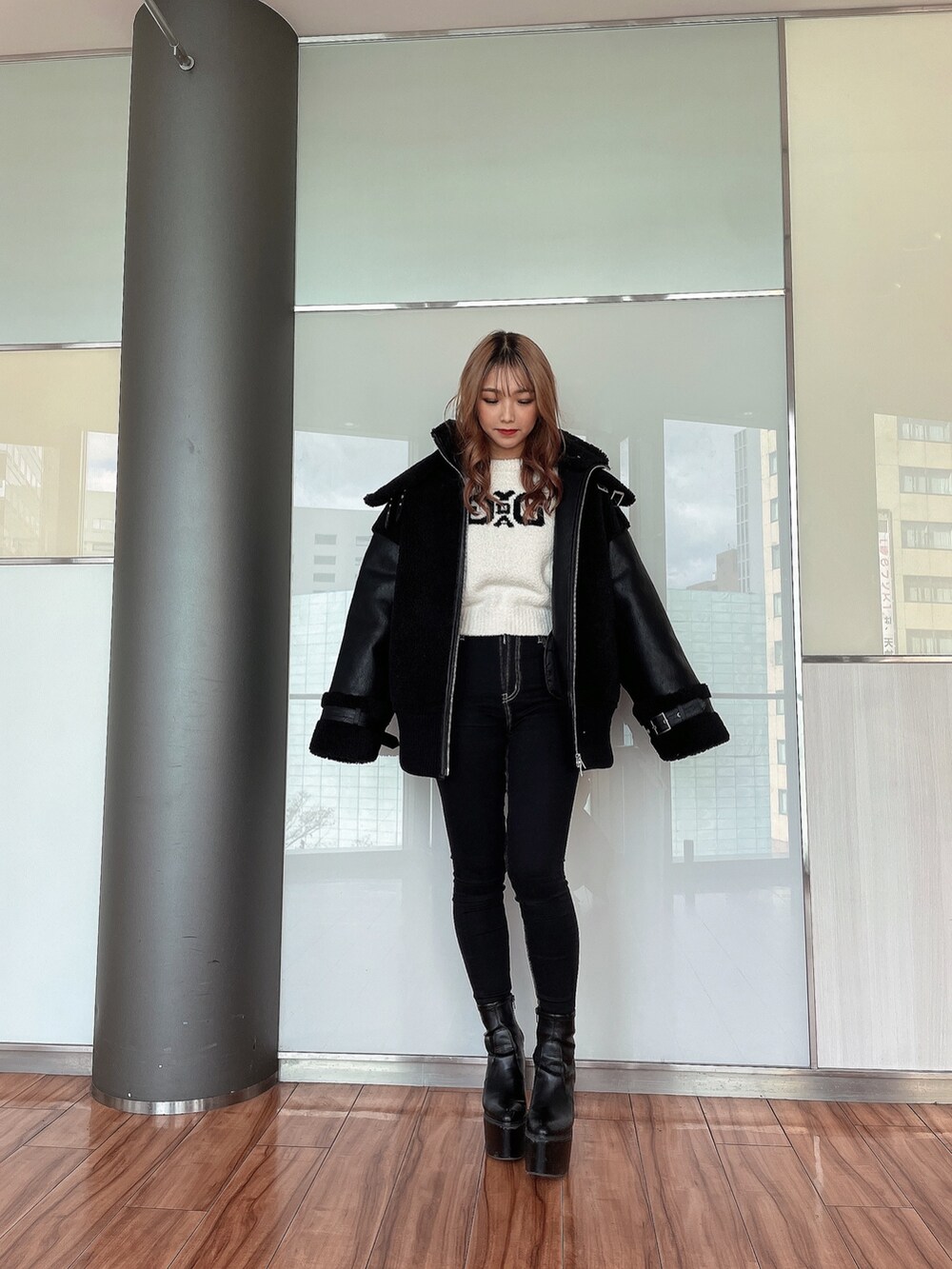 ホワイト系のニット/セーター、ブラック系のブルゾン、ブラック系のデニムパンツを着用したレディースの冬コーディネートの2枚目の写真