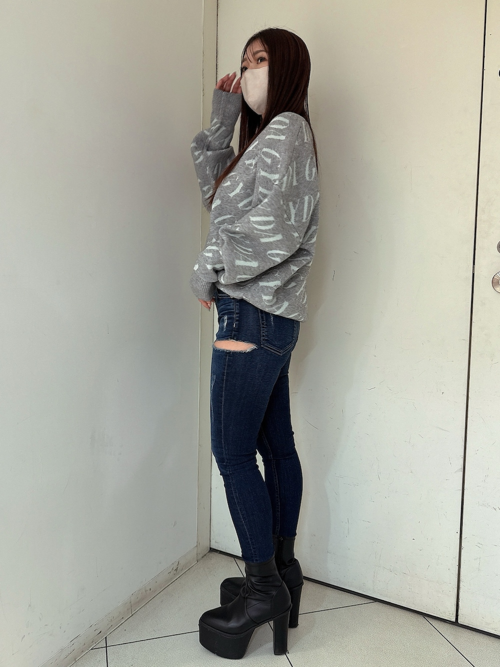 ブラック系のブーツ、ブルー系のデニムパンツ、グレー系のニット/セーターを着用したレディースの冬コーディネートの2枚目の写真