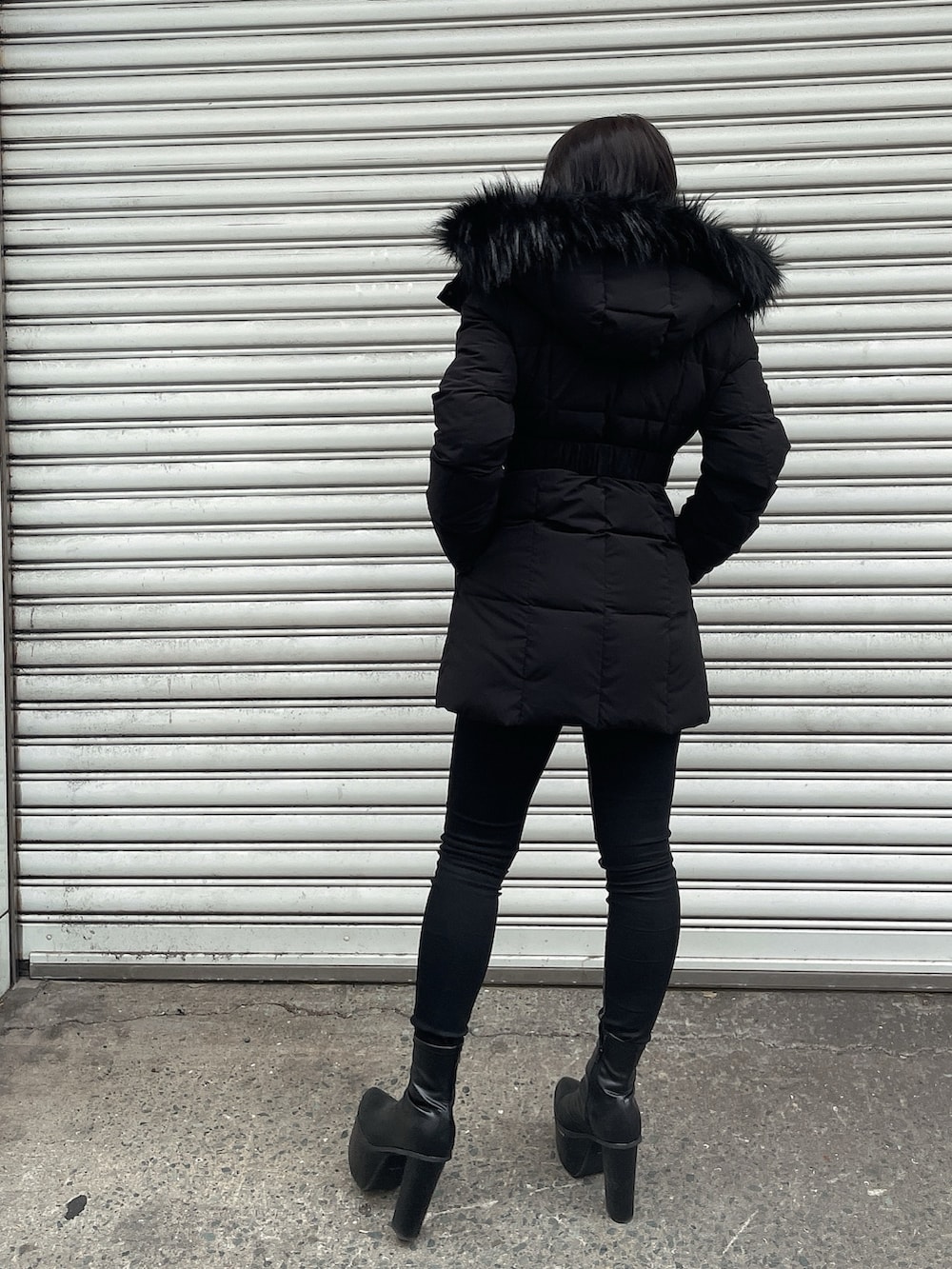 ブラック系のダウンジャケット/コート、ホワイト系のニット/セーター、ブラック系のデニムパンツを着用したレディースの冬コーディネートの3枚目の写真