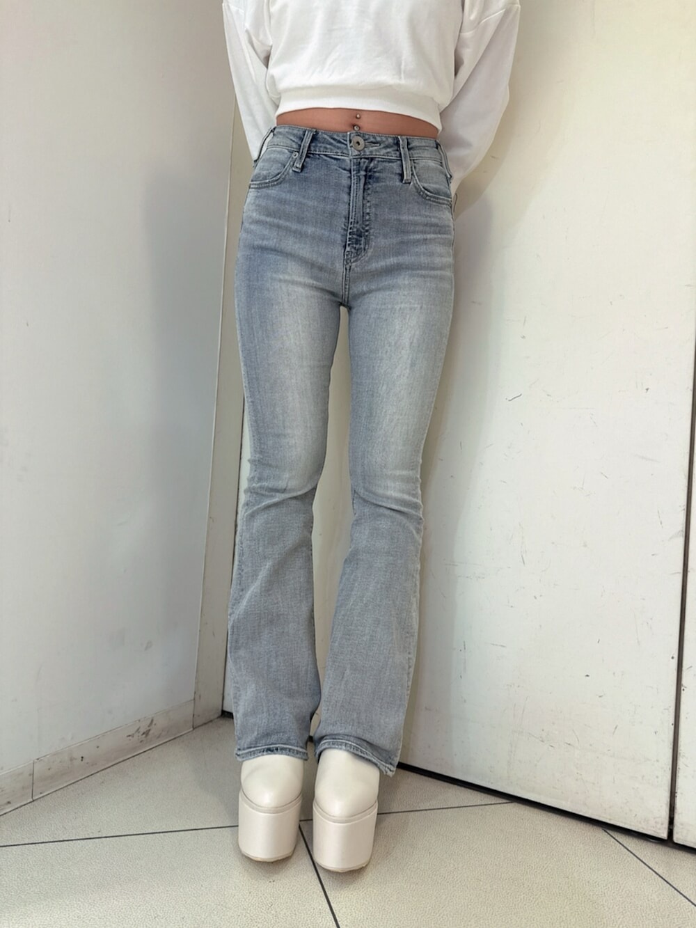 ブルー系のデニムパンツ、ホワイト系のスウェット、ホワイト系のブーツを着用したレディースの夏コーディネートの8枚目の写真