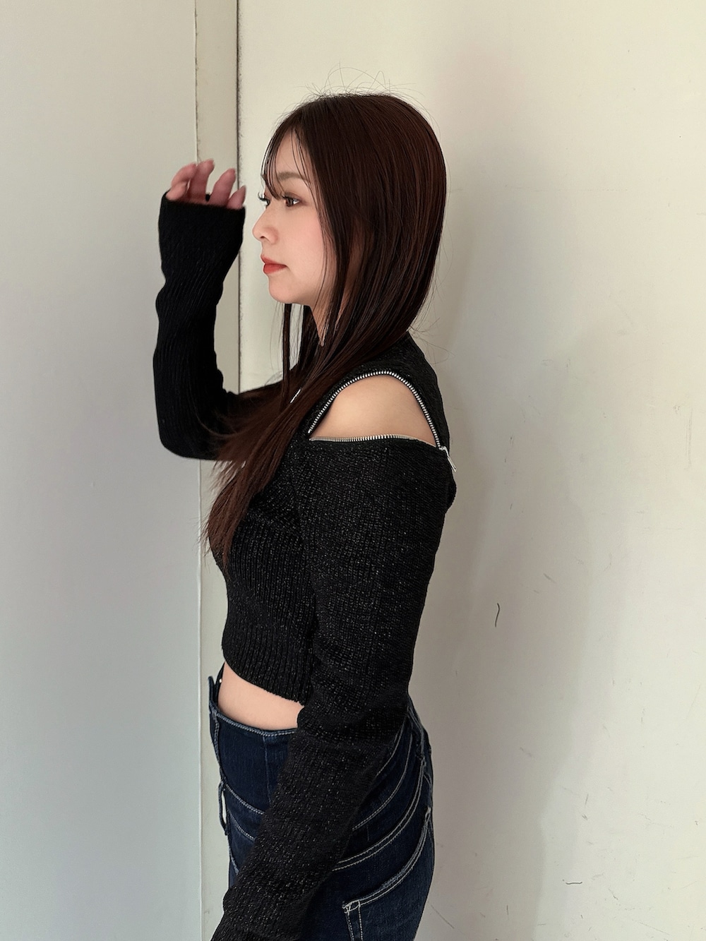 ブルー系のデニムパンツ、ブラック系のブーツ、ブラック系のニット/セーターを着用したレディースの冬コーディネートの5枚目の写真