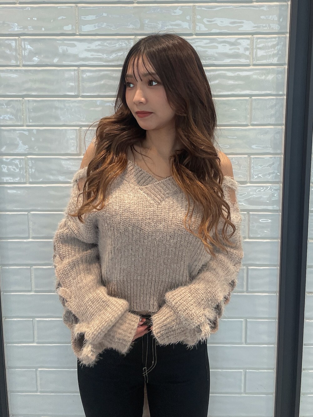 ベージュ系のニット/セーター、ブラック系のデニムパンツ、ブラック系のブーツを着用したレディースの秋コーディネートの4枚目の写真