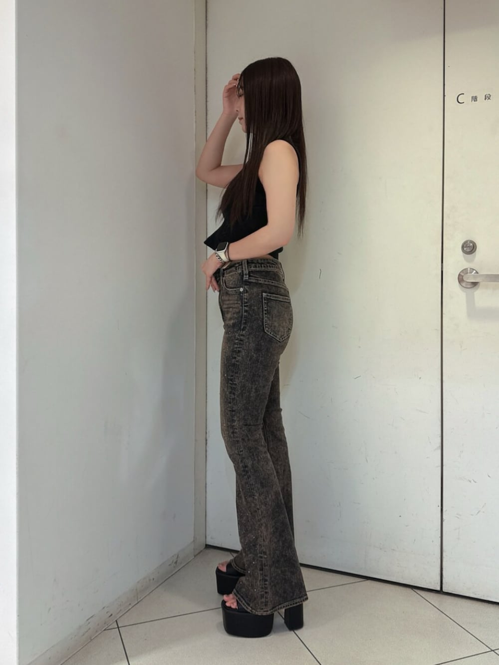 ブラック系のサンダル、ブルー系のデニムパンツ、ブラック系のタンクトップを着用したレディースの夏コーディネートの2枚目の写真