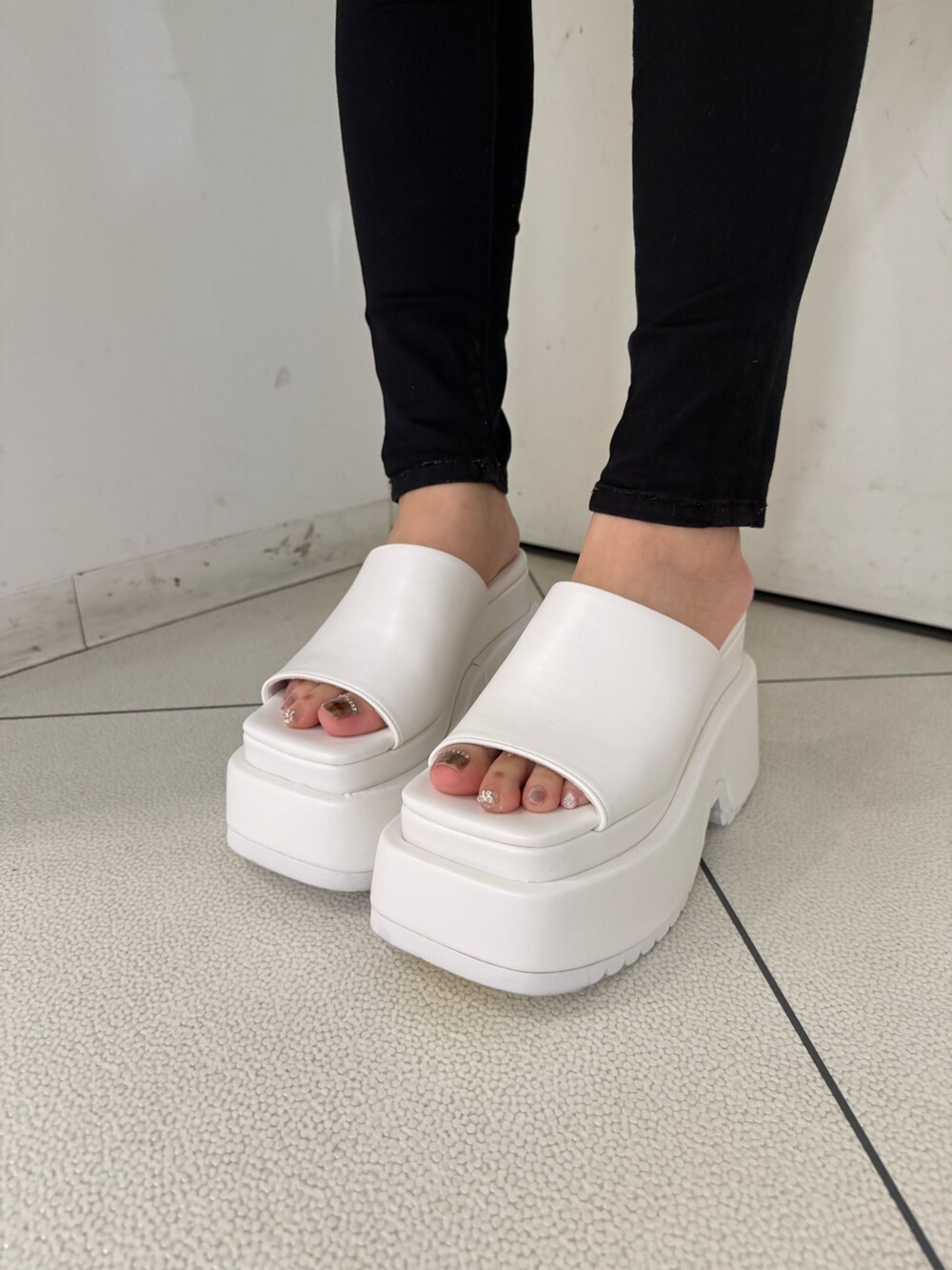 ブラック系のデニムパンツ、ホワイト系のサンダル、ホワイト系のキャミソールを着用したレディースの春コーディネートの8枚目の写真