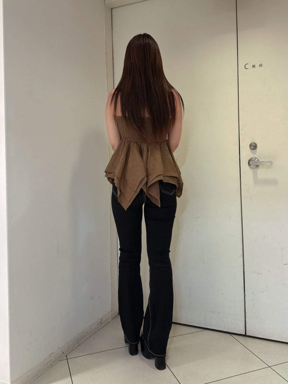 ブラック系のデニムパンツ、ブラック系のサンダル、ベージュ系のキャミソールを着用したレディースの夏コーディネートの3枚目の写真
