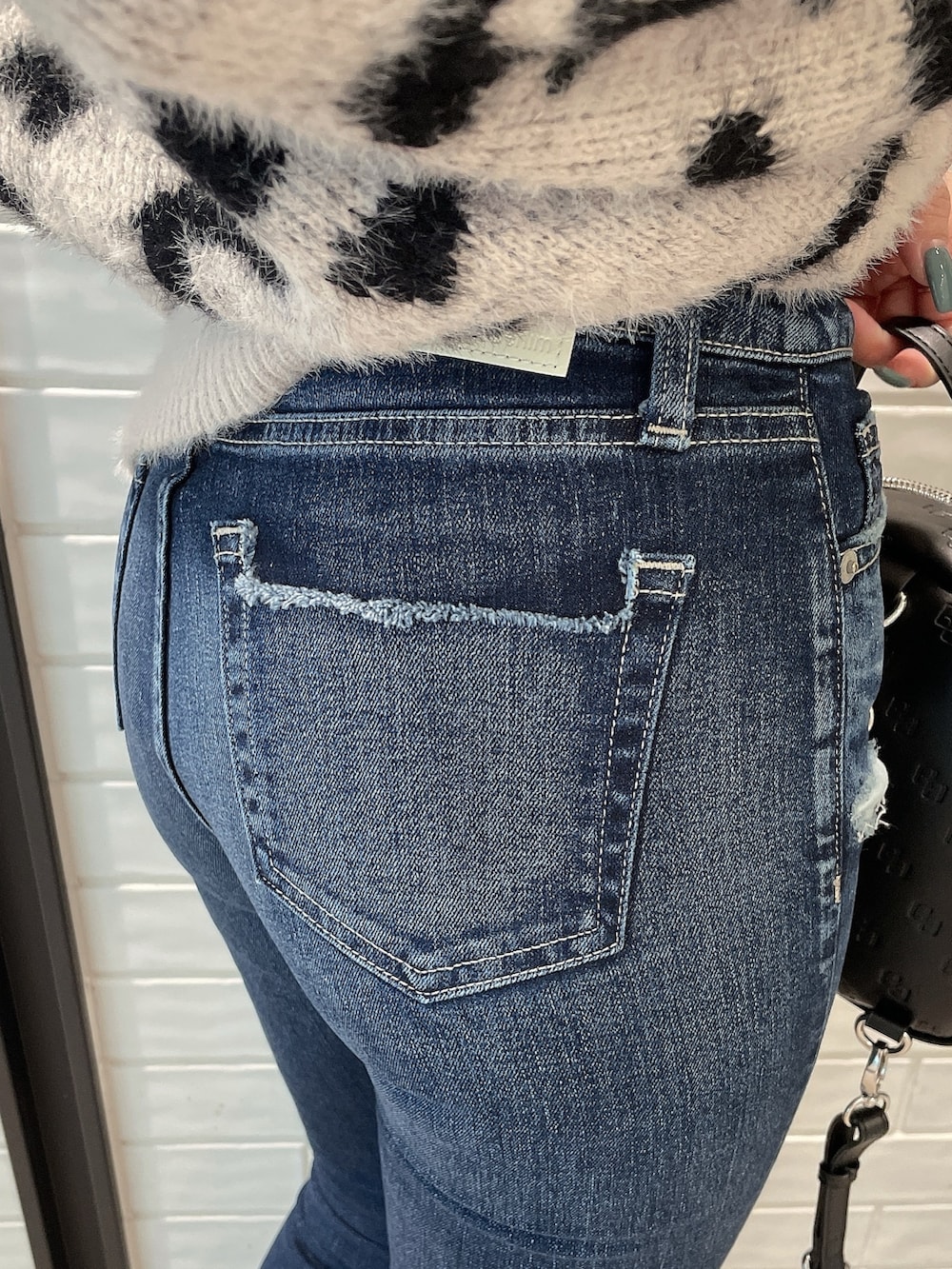 ホワイト系のニット/セーター、ブラック系のバックパック/リュック、ブラック系のパンプスを着用したレディースの冬コーディネートの7枚目の写真