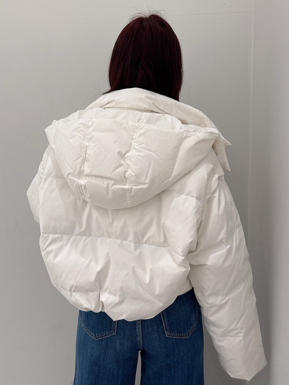 ホワイト系のダウンジャケット/コート、ブルー系のデニムパンツ、ブラック系のブーツを着用したレディースの秋コーディネートの5枚目の写真