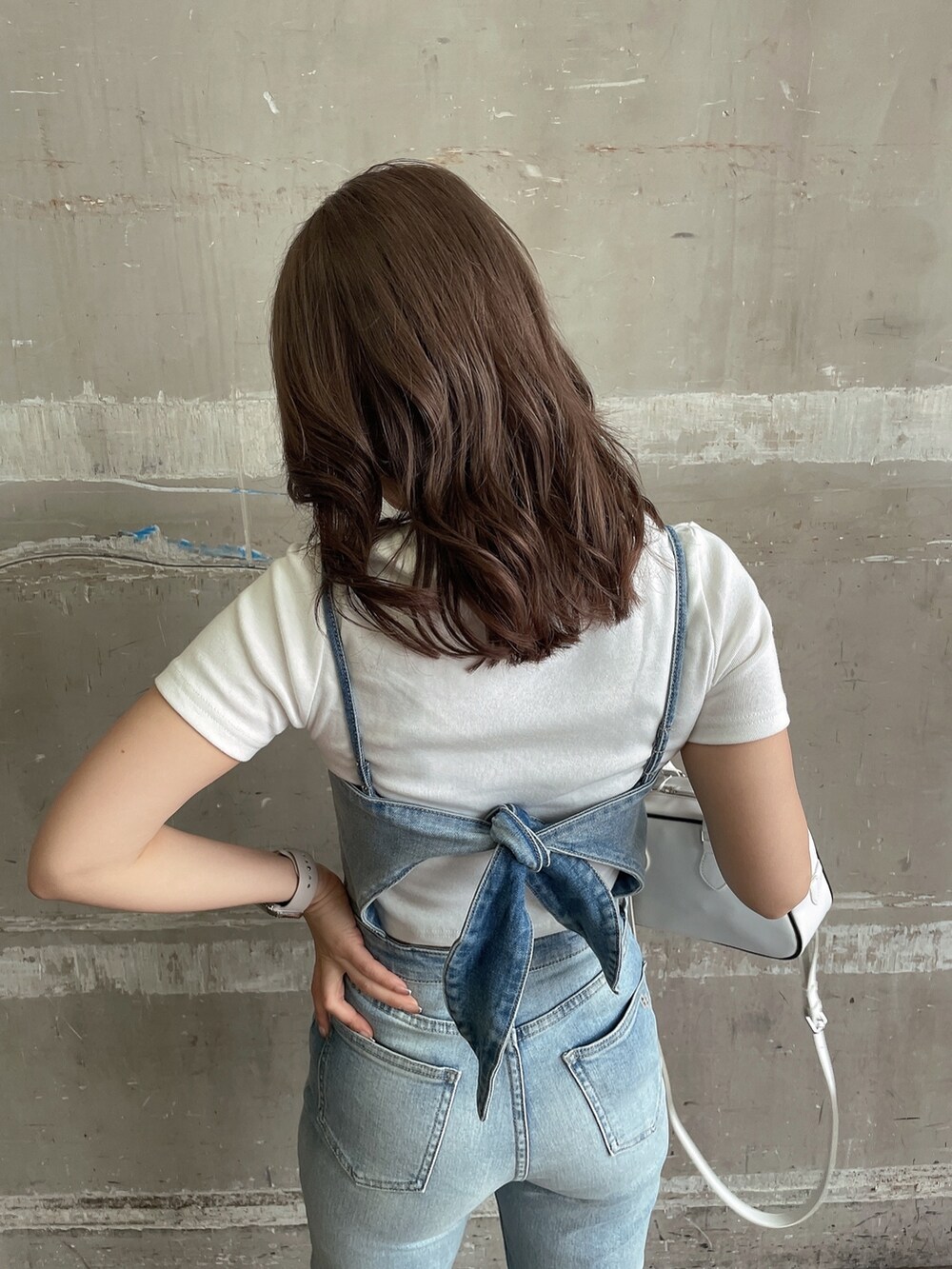 ホワイト系のTシャツ/カットソー、ホワイト系のハンドバッグ、ホワイト系のパンプスを着用したレディースの春コーディネートの4枚目の写真