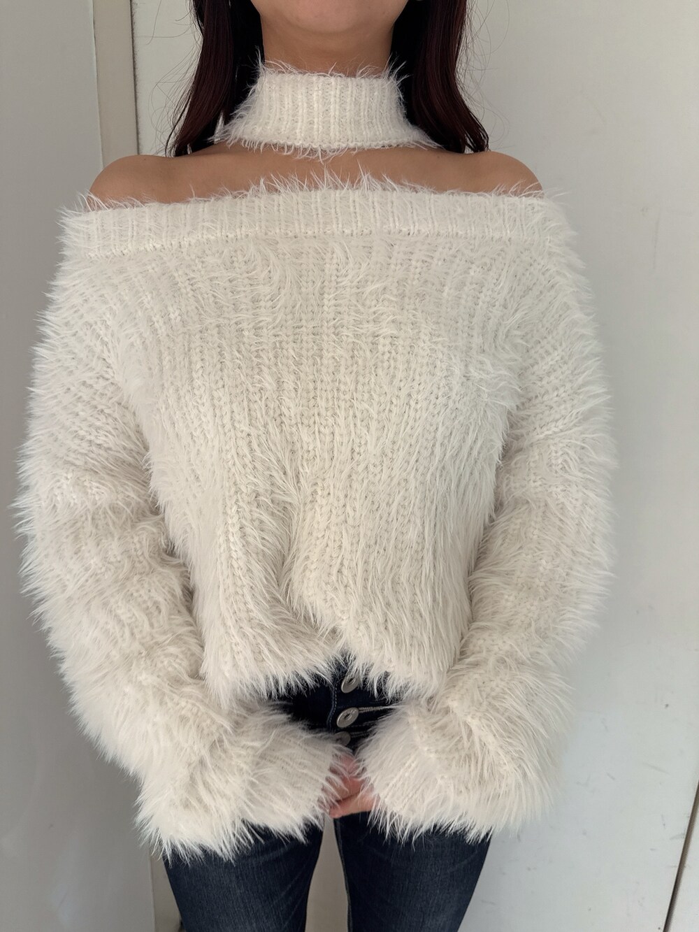ホワイト系のニット/セーター、ブルー系のデニムパンツ、ホワイト系のパンプスを着用したレディースの秋コーディネートの7枚目の写真