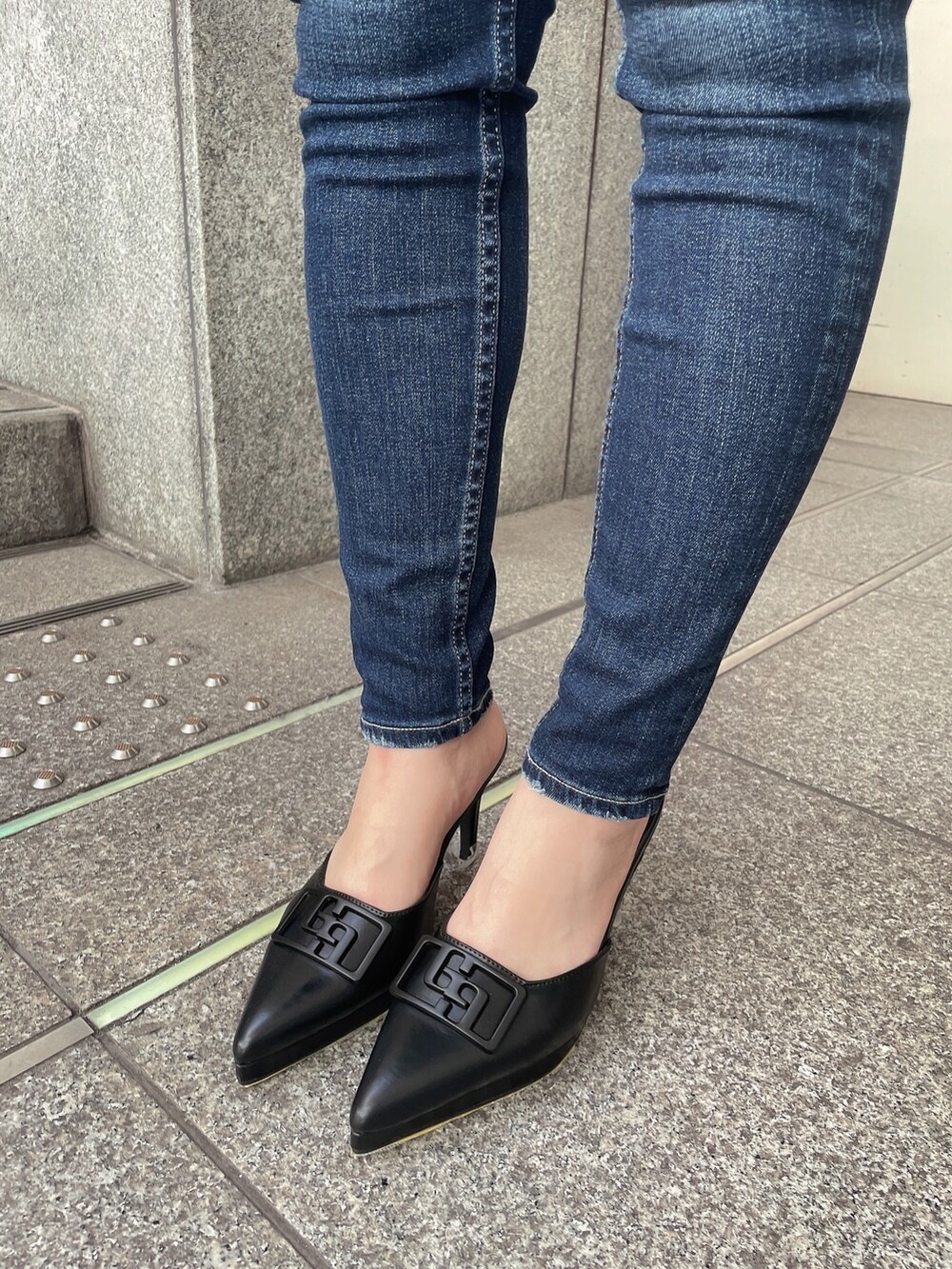 ブルー系のデニムパンツ、ブラック系のパンプス、ブラック系のTシャツ/カットソーを着用したレディースの春コーディネートの7枚目の写真