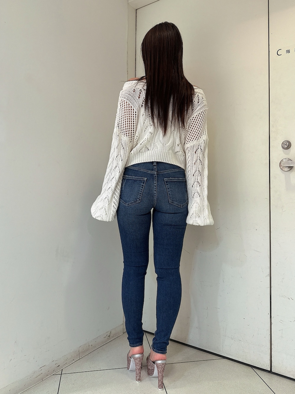 ホワイト系のニット/セーター、ブルー系のデニムパンツ、ピンク系のパンプスを着用したレディースの春コーディネートの3枚目の写真