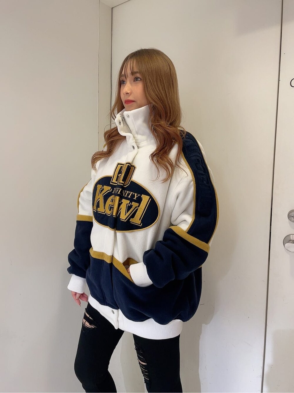 ブラック系のデニムパンツ、ブラック系のデニムパンツ、ホワイト系のブルゾンを着用したレディースの秋コーディネートの4枚目の写真