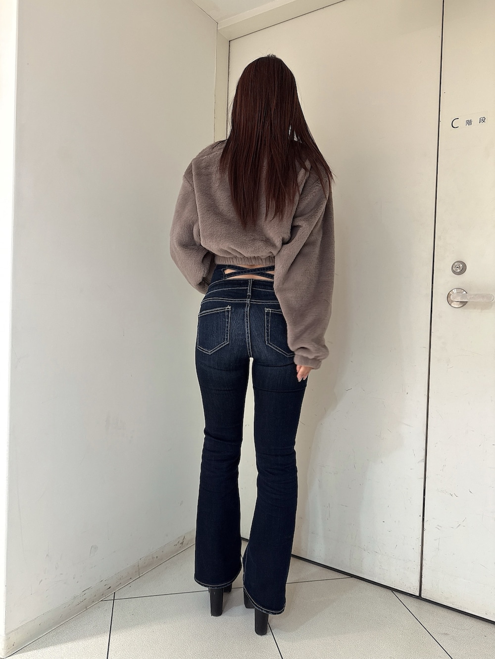 ブラック系のブーツ、ブルー系のデニムパンツ、ベージュ系のTシャツ/カットソーを着用したレディースの秋コーディネートの3枚目の写真