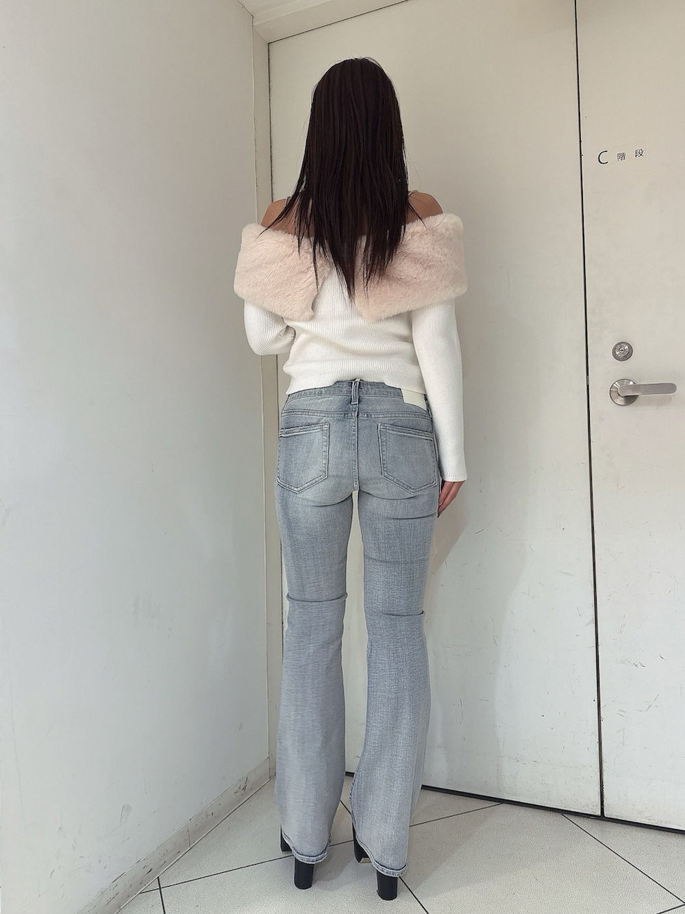 ホワイト系のニット/セーター、ブルー系のデニムパンツ、ブラック系のブーツを着用したレディースの秋コーディネートの3枚目の写真