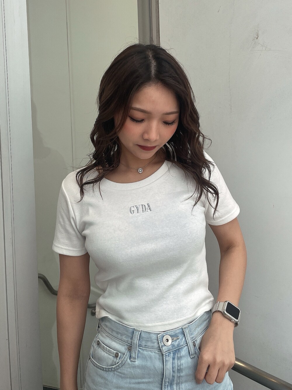 ホワイト系のTシャツ/カットソー、ブルー系のデニムパンツ、ブラック系のバックパック/リュックを着用したレディースの春コーディネートの4枚目の写真