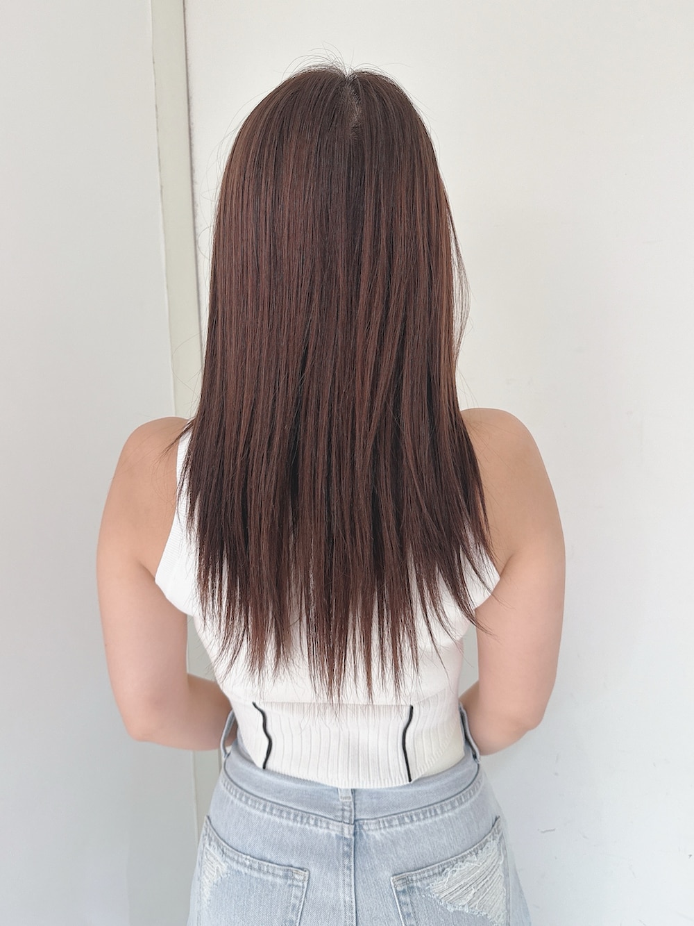 ホワイト系のニット/セーター、ブルー系のデニムパンツ、ホワイト系のサンダルを着用したレディースの夏コーディネートの6枚目の写真