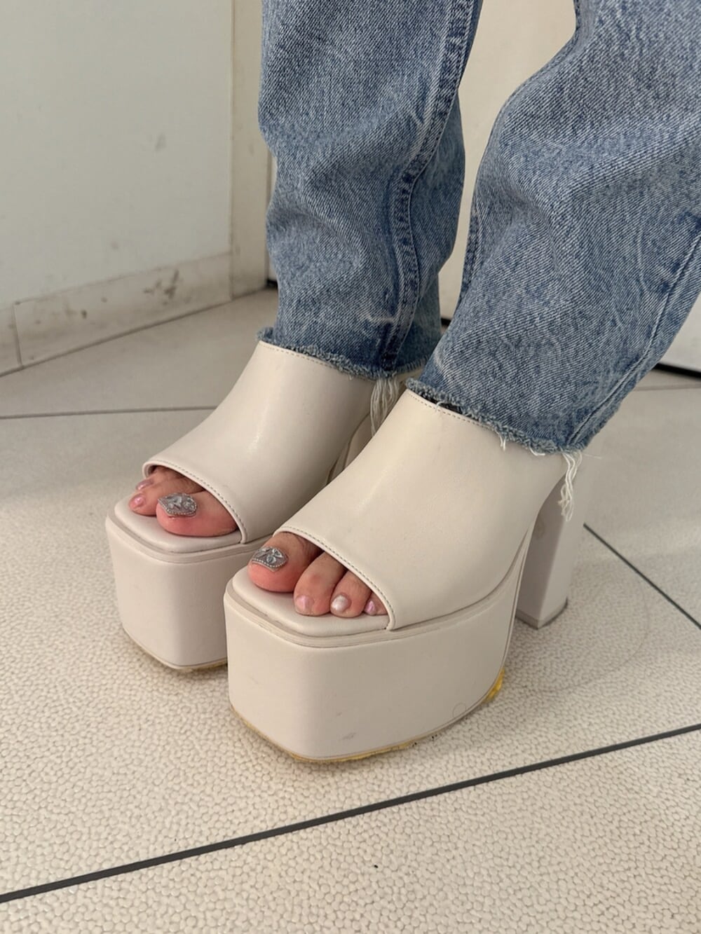 ブラック系のサンダル、ブルー系のデニムパンツ、ホワイト系のキャミソールを着用したレディースの夏コーディネートの9枚目の写真