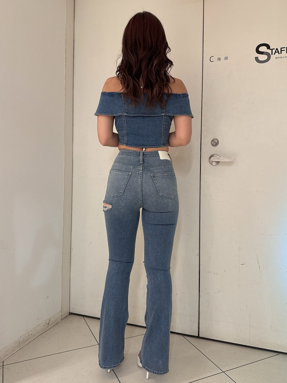 ブルー系のTシャツ/カットソー、ブルー系のデニムパンツ、ホワイト系のパンプスを着用したレディースの冬コーディネートの3枚目の写真