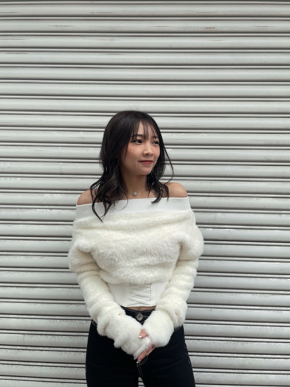 ブラック系のダウンジャケット/コート、ホワイト系のニット/セーター、ブラック系のデニムパンツを着用したレディースの冬コーディネートの8枚目の写真