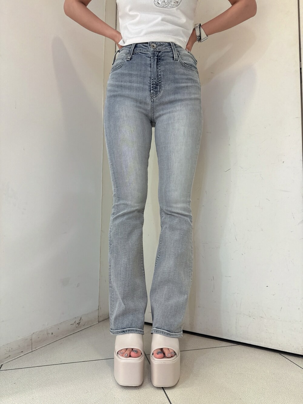 ブルー系のデニムパンツ、ブラック系のサンダル、ホワイト系のキャミソールを着用したレディースの春コーディネートの8枚目の写真