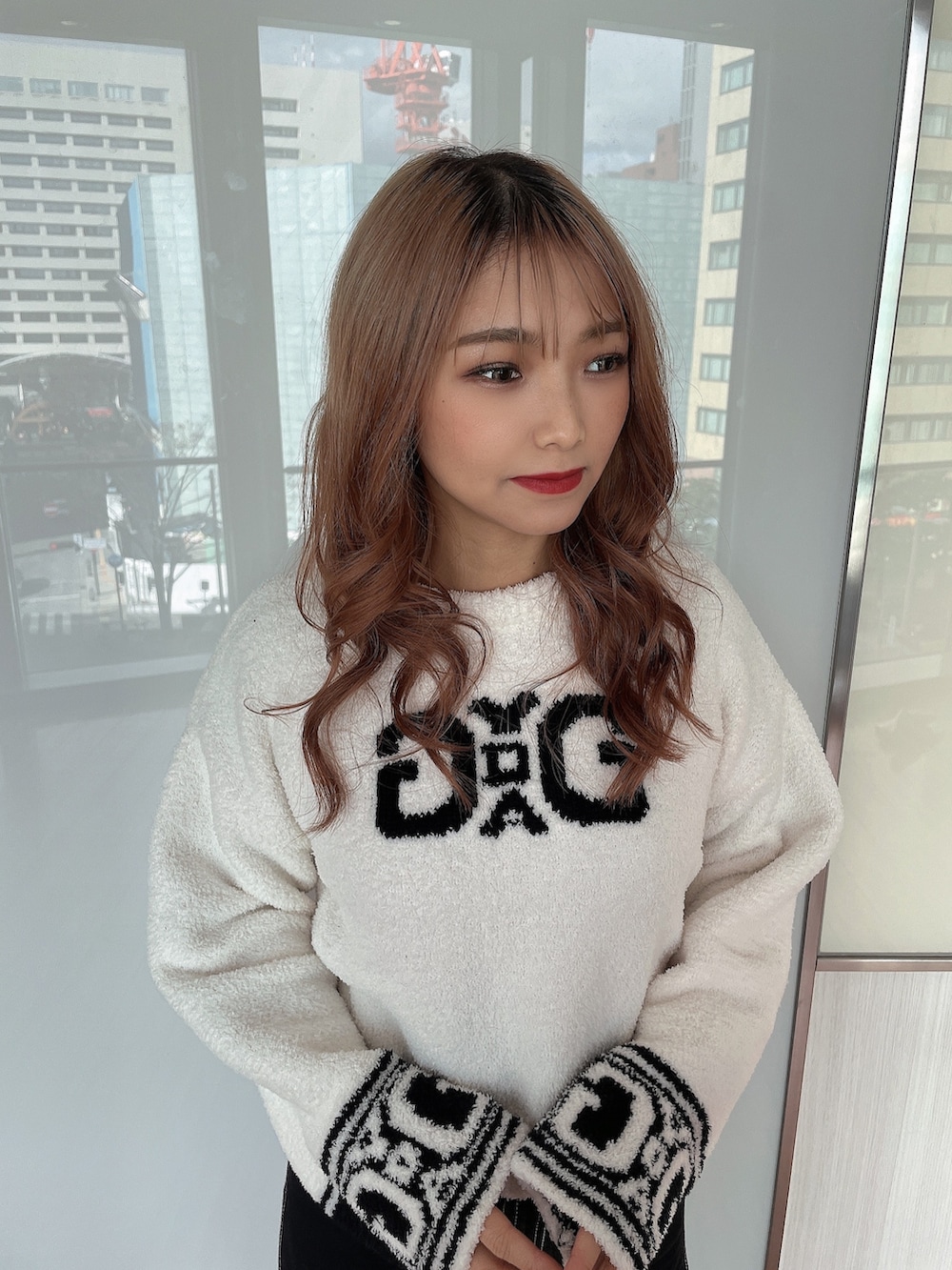 ホワイト系のニット/セーター、ブラック系のブルゾン、ブラック系のデニムパンツを着用したレディースの冬コーディネートの5枚目の写真