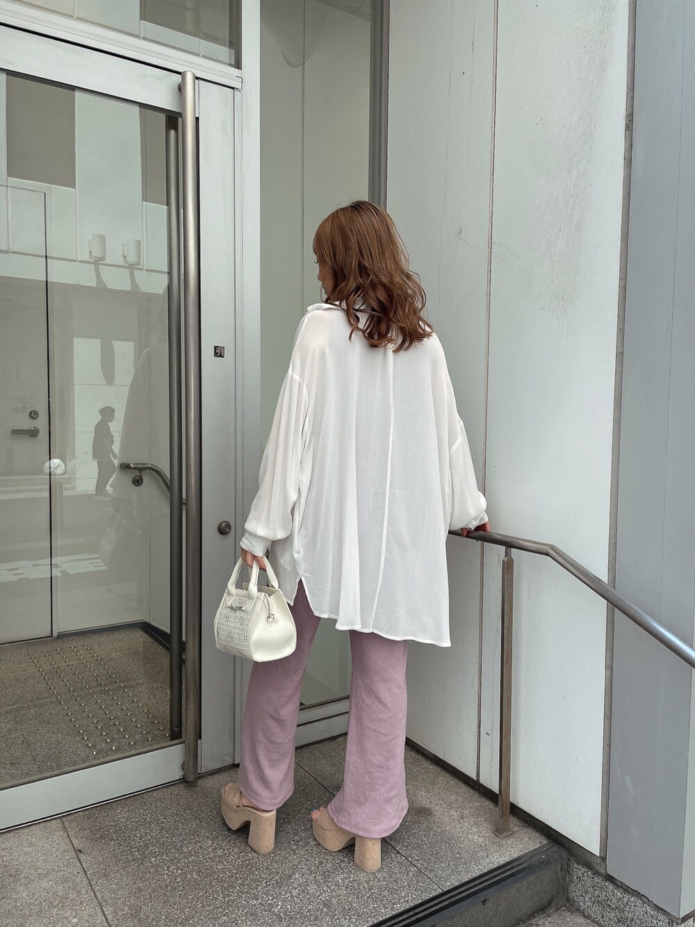 ピンク系のつなぎ/オールインワン、ホワイト系のシャツ/ブラウス、ホワイト系のハンドバッグを着用したレディースの春コーディネートの2枚目の写真